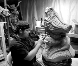 Brian Somerville working on sculpting one of his monsters in his studio.